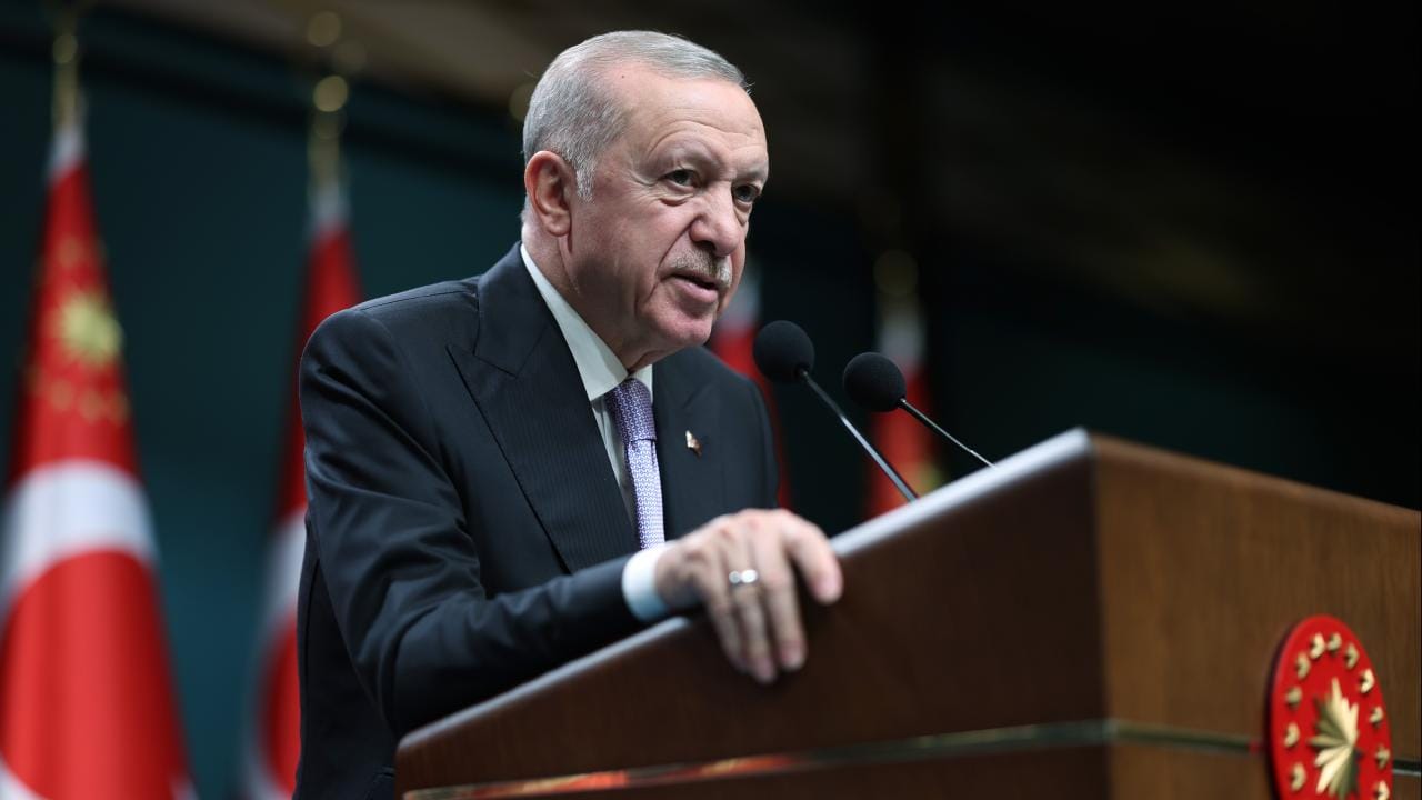Cumhurbaşkanı Erdoğan konuşma yaparken kürsü ve arkasında Türkiye bayrağı görünür