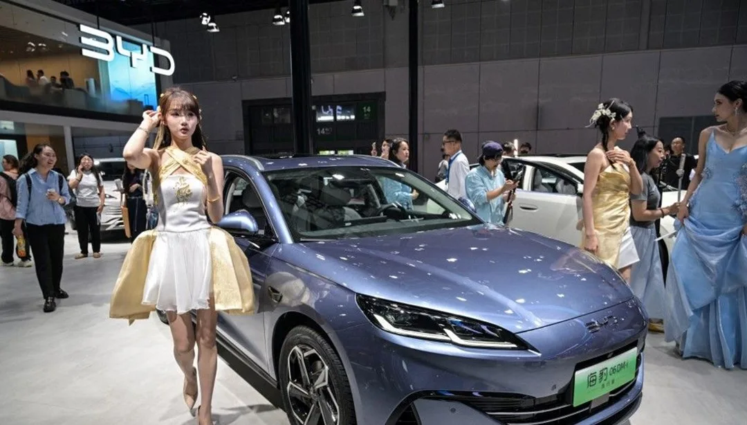 BYD logosu ve fabrikanın dış cephesi, şirketin tartışma veya kriz atmosferini yansıtır gibi