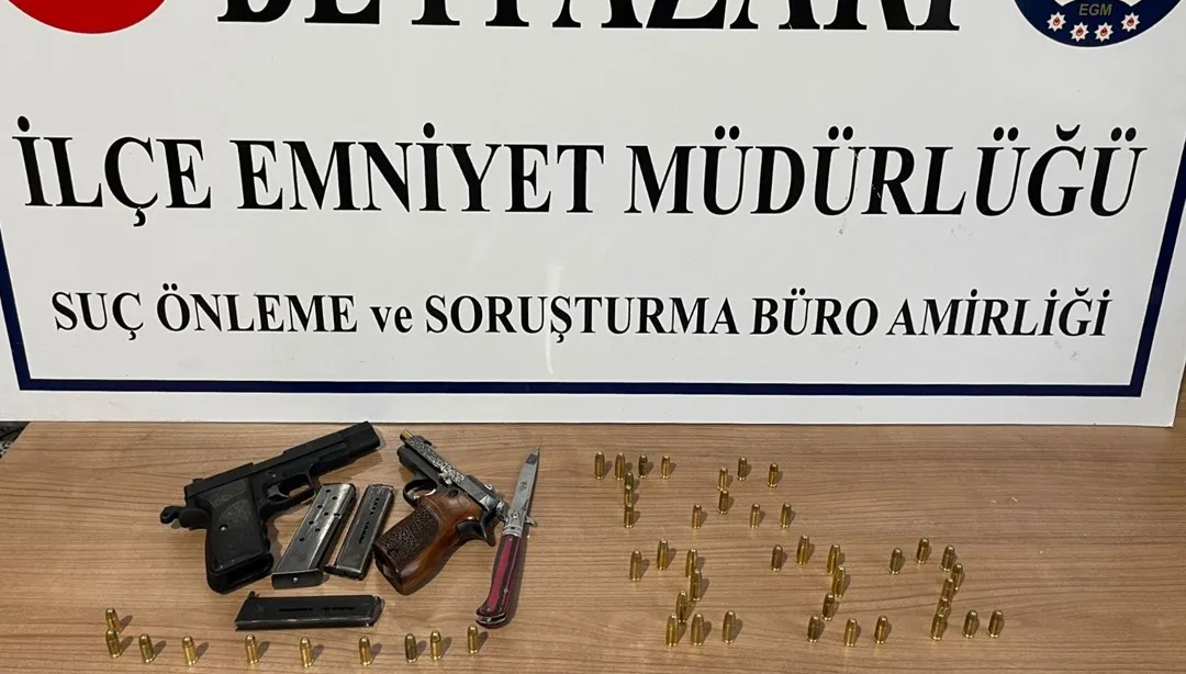Durdurma işlemi yapılan otomobilin yanından polislerin ve ele geçirilen iki tabancanın bulunduğu görüntü