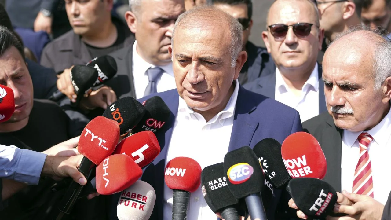 Gürsel Tekin konuşurken ciddi bir ifadeyle mikrofon önünde duruyor