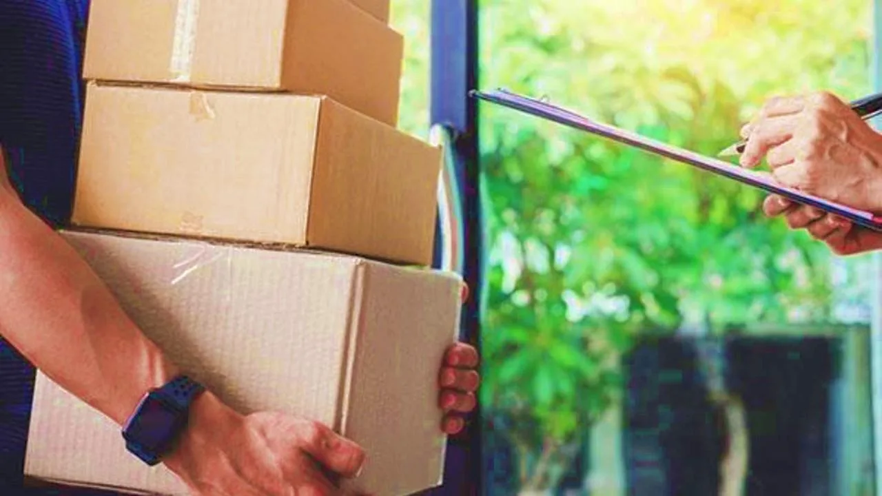 Kargoyu kapıda teslim alan bir kişi veya teslimat kutusu; kapı ve paket odaklı görüntü