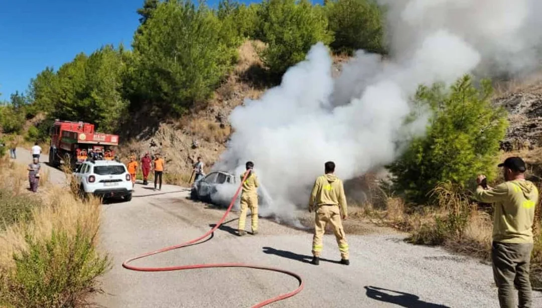 Orman ekiplerinin yanan araca müdahale ettiği an; söndürme çalışmaları ve ekipler görünür.
