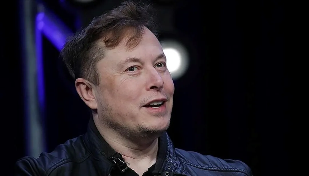 Elon Musk'ın Tesla logosu önünde ellerini birleştirmiş hali, umut ve başarı vurgusu
