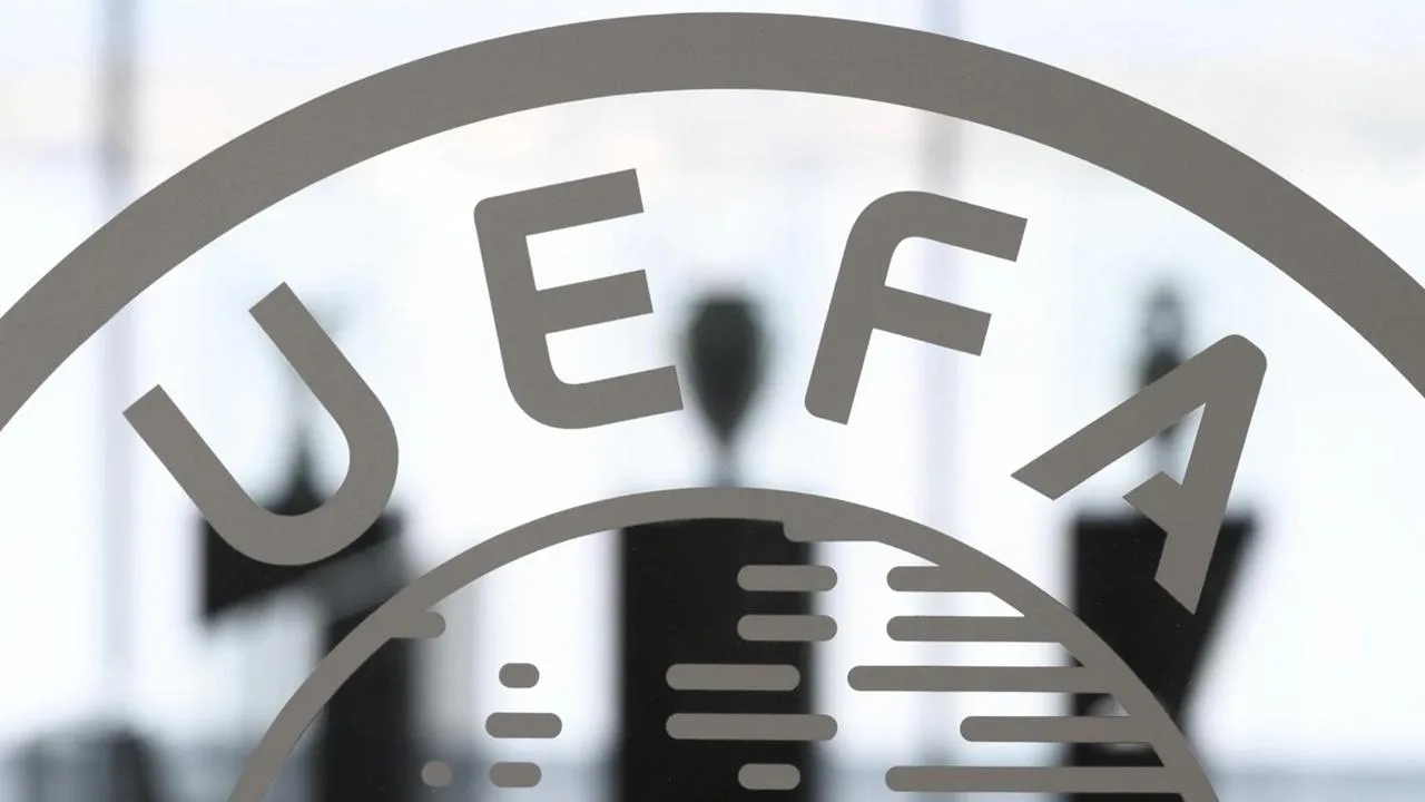 UEFA yetkilileri ve komite üyelerinin toplantı masasında oturduğunu gösteren basın toplantısı veya toplantı salonu sahnesi