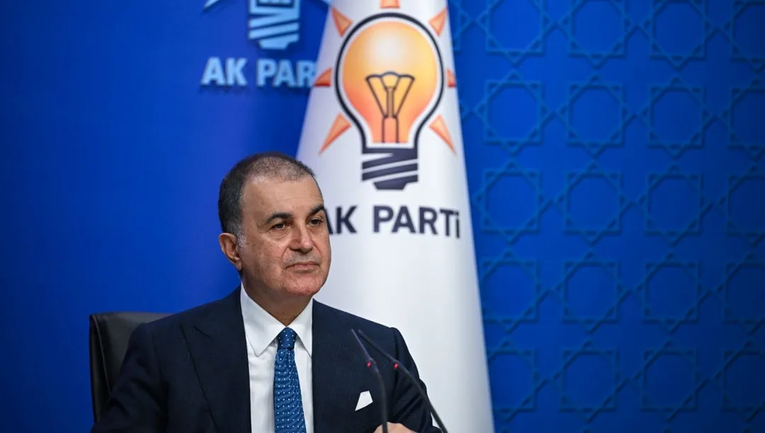 AK Parti Sözcüsü Ömer Çelik konuşurken, arka planda anısına fotoğraf veya çelenk olabilir.