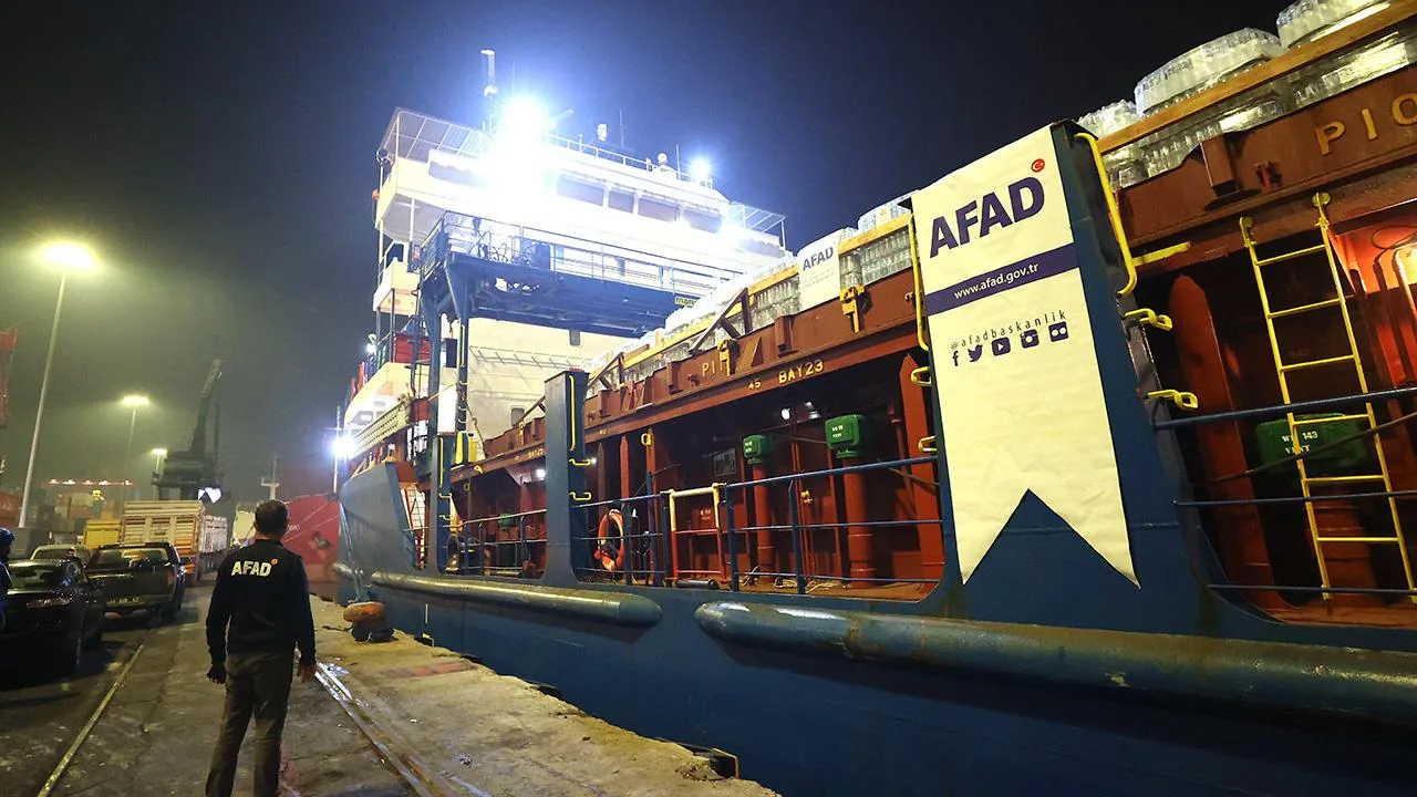 AFAD logosu ve insani yardım malzemeleriyle dolu konteynerlerin yer aldığı sahne