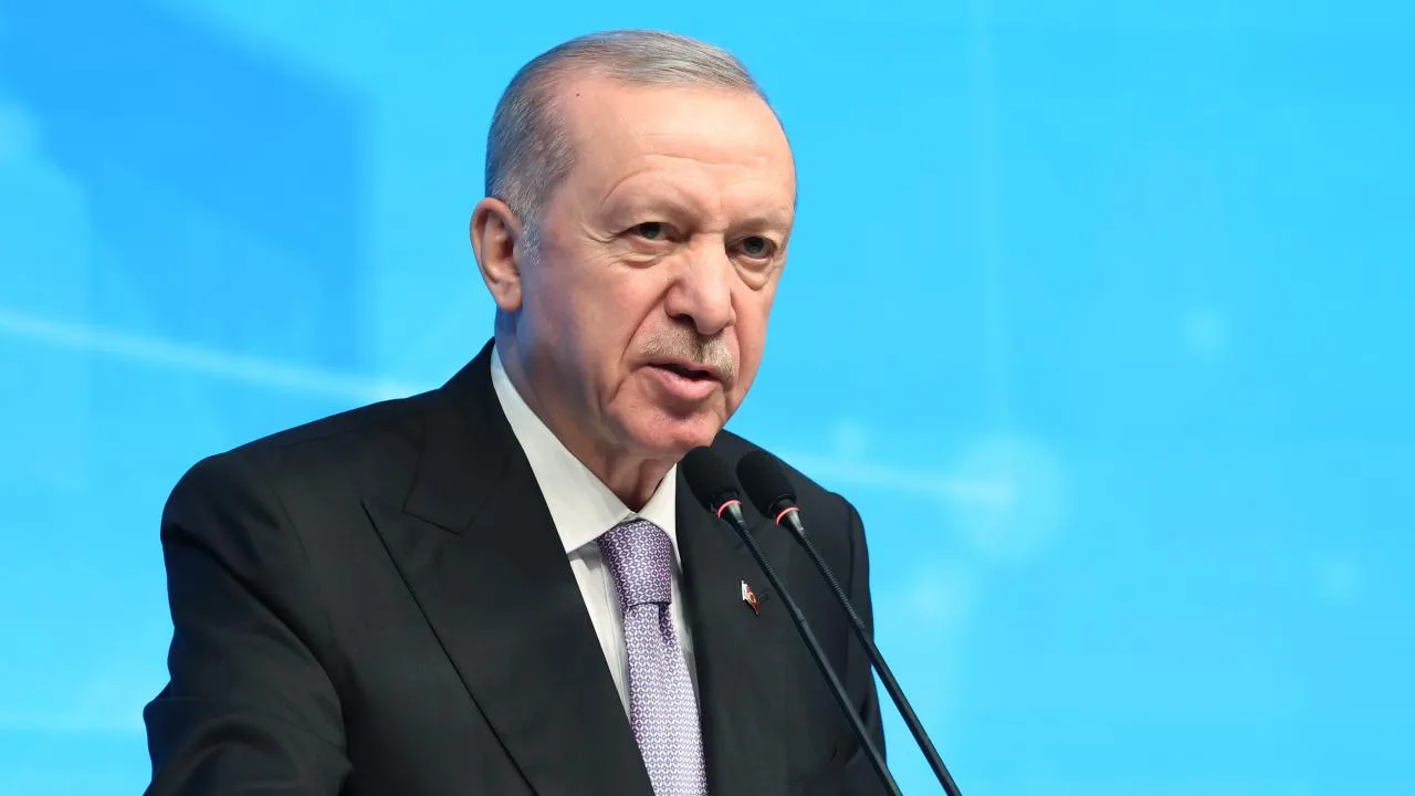 Cumhurbaşkanı Erdoğan konuşma yaparken kürsüde mikrofonların önünde duruyor