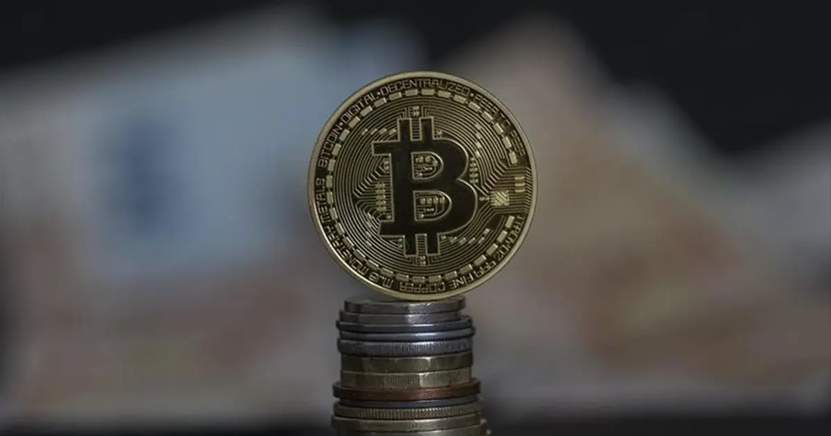 Kripto analisti konuşurken el hareketi yapıyor; arka planda grafik ve ekranlar görülüyor