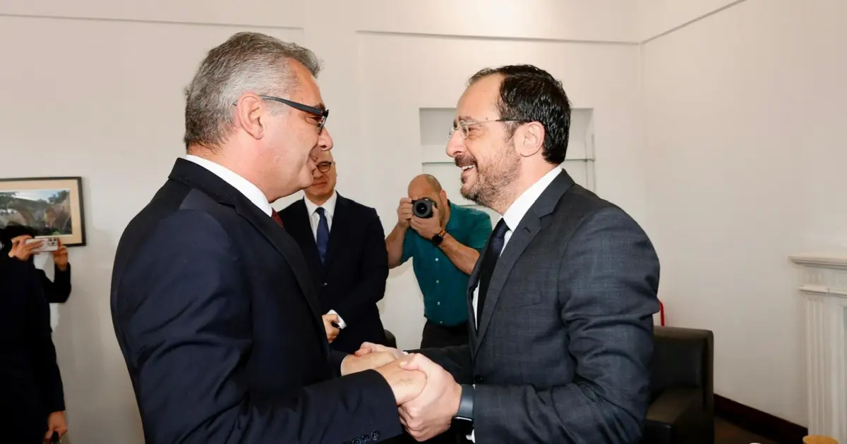 KKTC Cumhurbaşkanı Erhürman resmi tören veya görüşme ortamında, takım elbise giyiyor