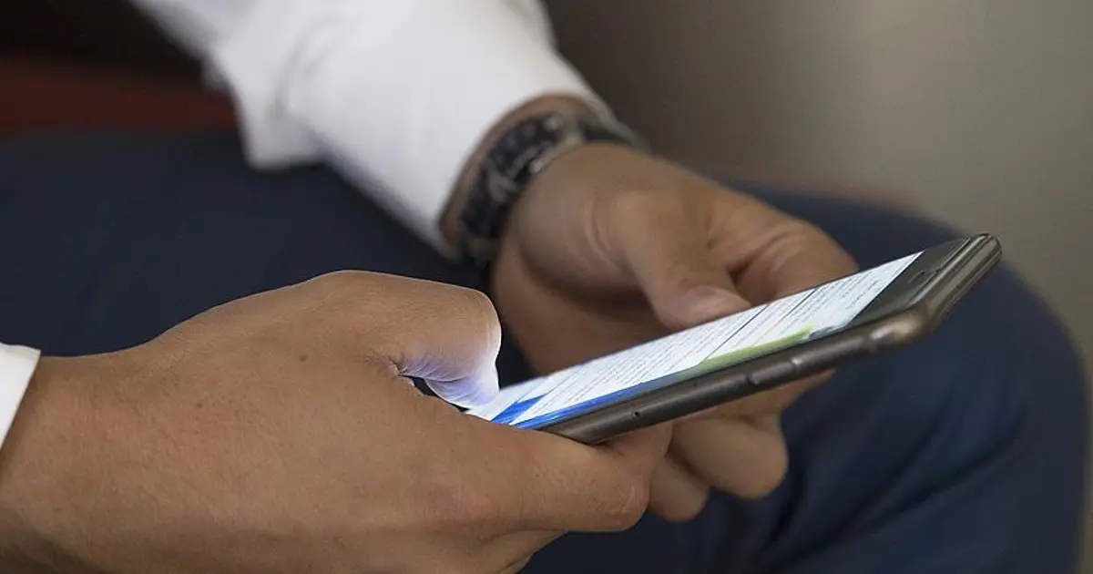 Karanlık arka planda bir akıllı telefon ekranı ve mesaj balonları, güvenlik tehdidini çağrıştıran kompozisyon