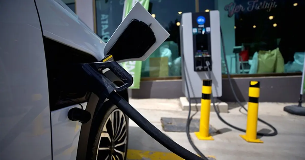 Elektrikli araç şarj istasyonunda şarj kablosu ve göstergeler; ek ücretlerin yasaklandığını vurgulayan haber görseli