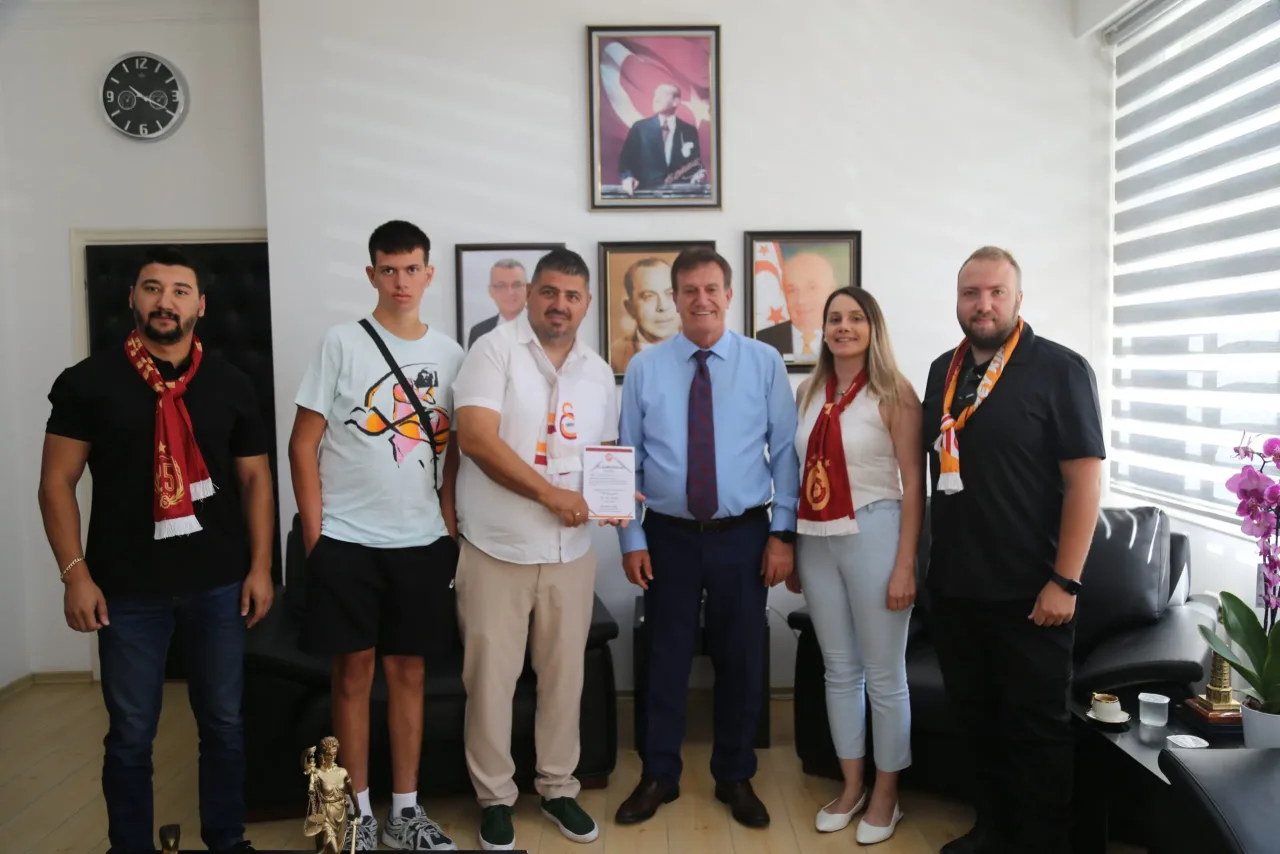 Bayındırlık ve Ulaştırma Bakanı Arıklı, KKTC Galatasaraylılar Derneği üyeleriyle görüşürken el sıkışıyor