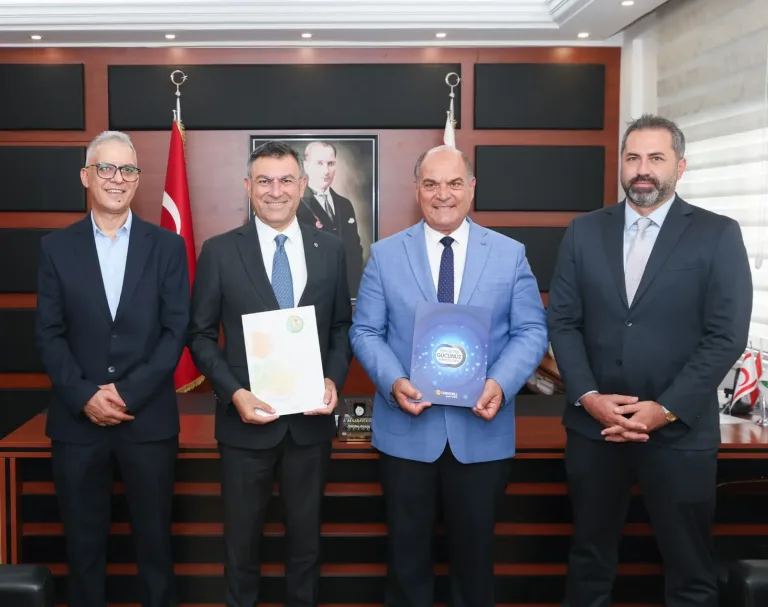 Değirmenlik Akıncılar Belediyesi ve Kuzey Kıbrıs Turkcell yetkilileri protokol imza töreninde masa etrafında duruyor