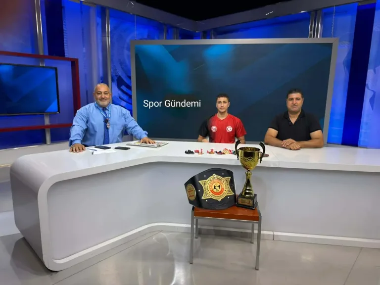 Spor Gündemi program stüdyosunda konuşan Enes Erdem, konuk koltuğunda mikrofonla