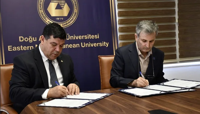 DAÜ ve Kharazmı Üniversitesi temsilcilerinin protokol imzalama anı, masada belgeler