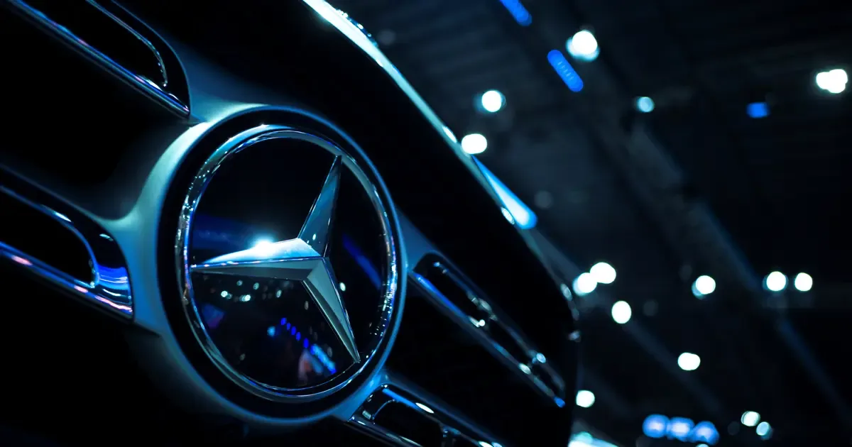 Mercedes logosu ve bir otomobil ön kısmını gösteren yakın çekim görüntüsü, geri çağırma haberini temsil ediyor