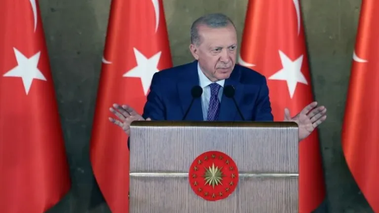 Erdoğan konuşma yaparken kürsüde mikrofonların önünde duruyor