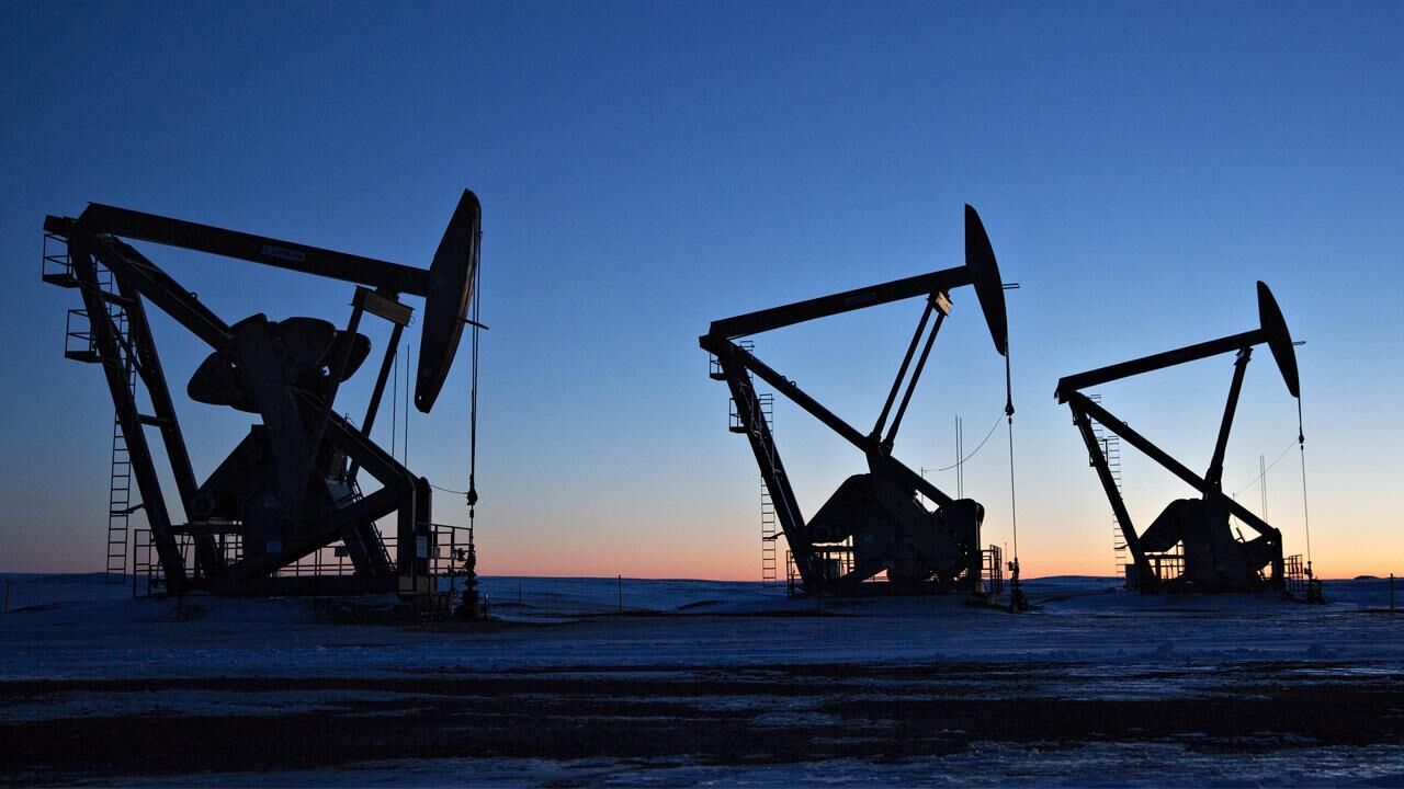 Brent petrol fiyatlarının düşüşünü simgeleyen grafikli ekran ve finans haberleri gösteren metinler