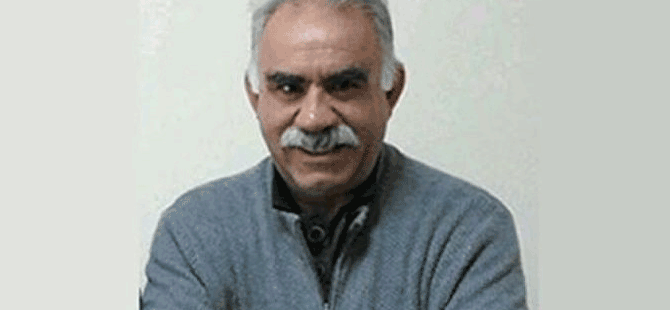 DEM Partili Pervin Buldan konuşurken, arka planda parti bayrakları ve mikrofonlar görünüyor