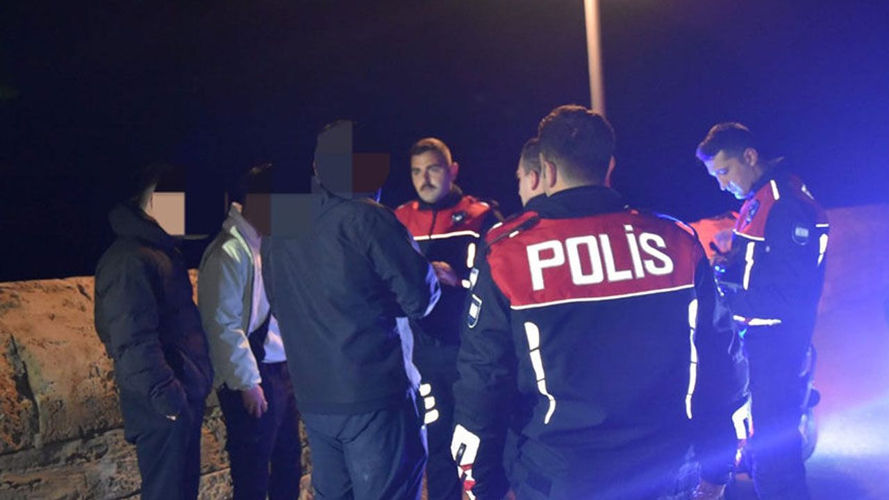 Barkodlu bileklikli ve kelepçeli zanlıların polis eşliğinde kelepçelendiği soruşturma görüntüsü
