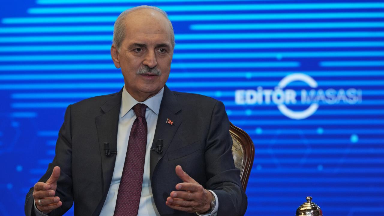 Kurtulmuş konuşma yaparken kürsü önünde hitap ediyor, arka planda Türkiye bayrağı ve salon görüntüsü