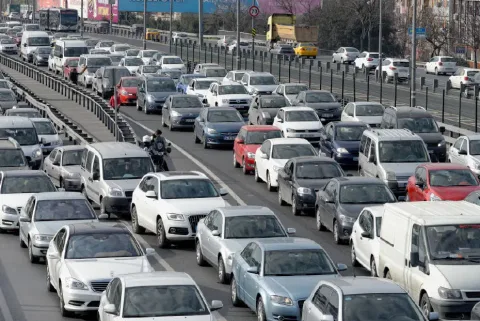 Araçların bir yol kenarında beklediği veya park ettiği, sürücülerin araçlarına bakıyor olabileceği bir sahne