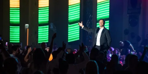 Mahsun Kırmızıgül sahnede mikrofonla performans sergiliyor
