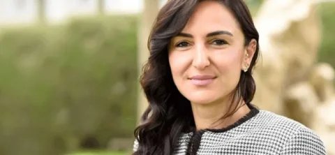 Jale Refik Rogers konuşma yaparken mikrofon önünde, yüz ifadesi kararlı