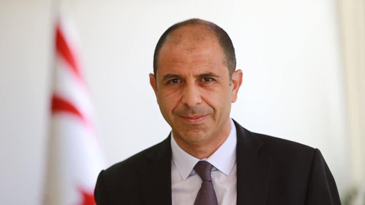Özersay konuşurken mikrofon önünde, partililer arka planda bulunuyor