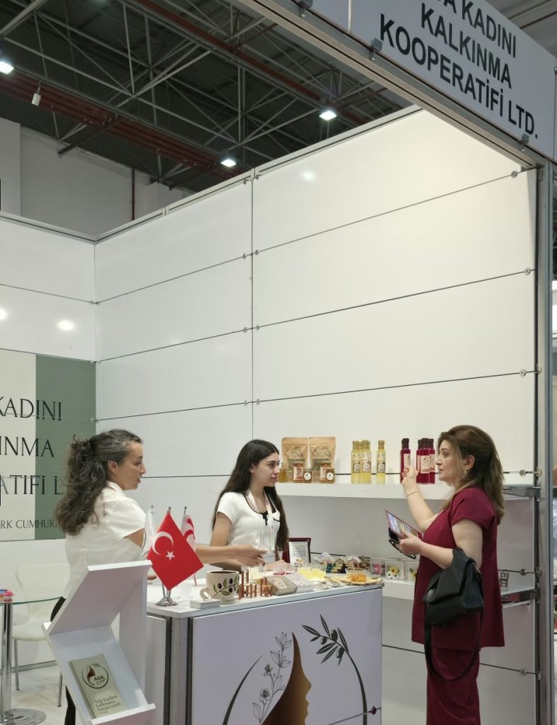 KKTC standı ve katılımcılar, İzmir'deki fuarda ziyaretçilerle etkileşimde