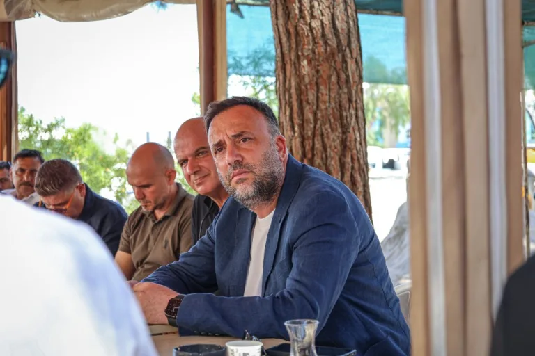 Çeler konuşurken mikrofon önünde duruyor, vurgu yapar şekilde el hareketi yapıyor