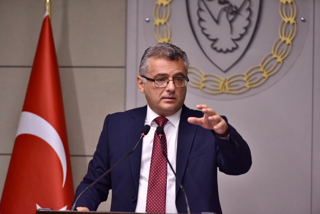 Cumhurbaşkanı Erhürman konuşurken mikrofon ve masa önünde görünür