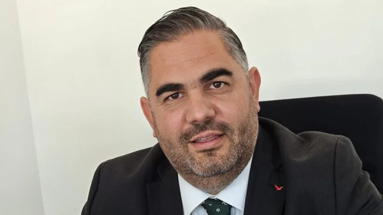 Rahvancıoğlu konuşurken mikrofonlu bir sahnede, belediye yatırımlarını vurguluyor