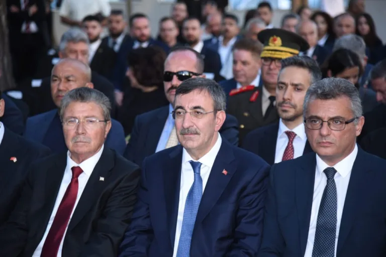 Erhürman konuşurken, arka planda Kıbrıs anılarına atıf yapan görsel öğeler