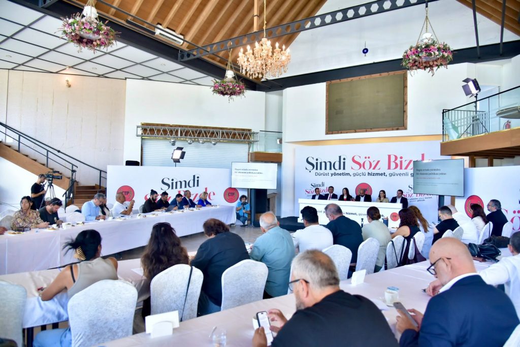 İncirli konuşurken mikrofon ve parti logosu önünde duruyor