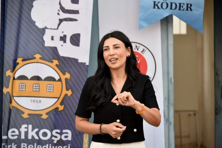 KÖDER kitap tanıtım etkinliğinde konuşmacılar ve katılımcılar sahnede oturuyor