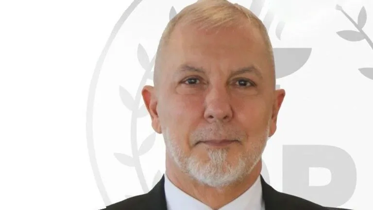 Akpınar konuşurken mikrofon ve DP bayrağı arka planda