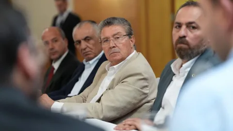 Üstel konuşuyor; arka planda proje görselleri ve dinleyenler