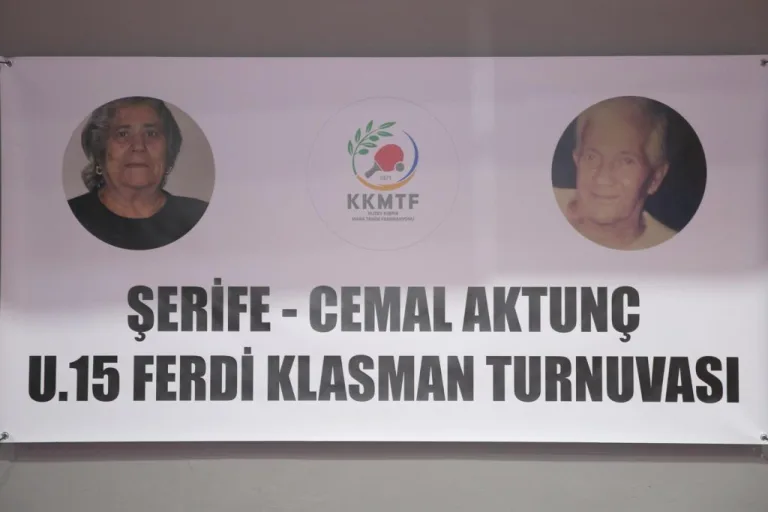 Aktunç konuşurken mikrofonla selamlıyor; arka planda spor temalı pankartlar ve belediye yetkilileri görünüyor