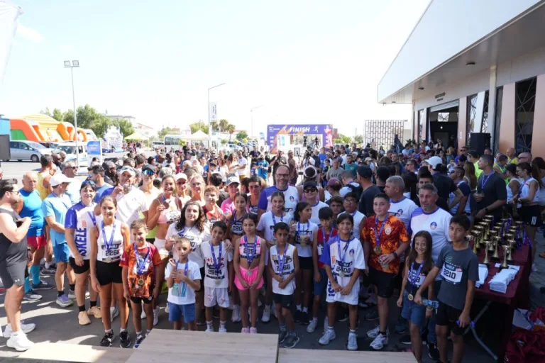 İskele Yarı Maratonu etkinliğinde katılımcılar koşuyor, Sadıkoğlu konuşma yapıyor
