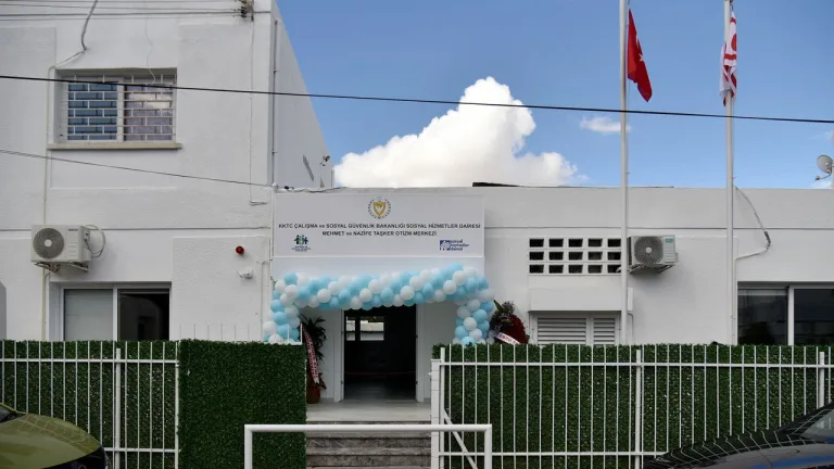 KKTC’de açılış törenindeki Otizm Merkezi girişinde kurdele kesme anı veya bina cephesi