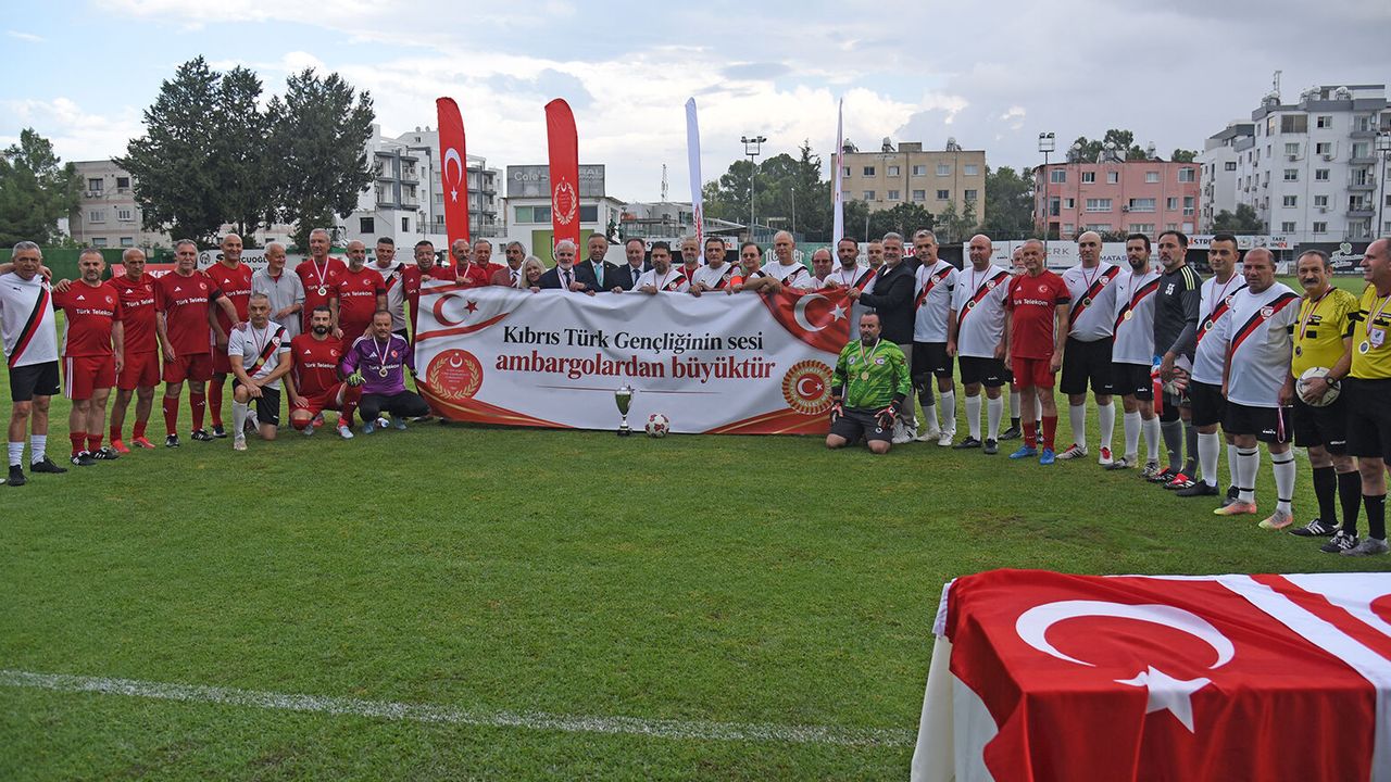 İzolasyon karşıtı dostluk maçında bir grup insan sahada el sıkışıyor veya omuz omuza duruyor