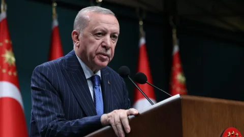 Cumhurbaşkanı Erdoğan konuşma yaparken kürsüde mikrofonların önünde duruyor