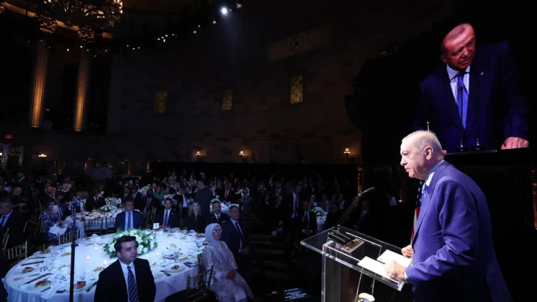 Cumhurbaşkanı Erdoğan kürsüde konuşuyor; arka planda Türk bayrağı ve toplantı atmosferi