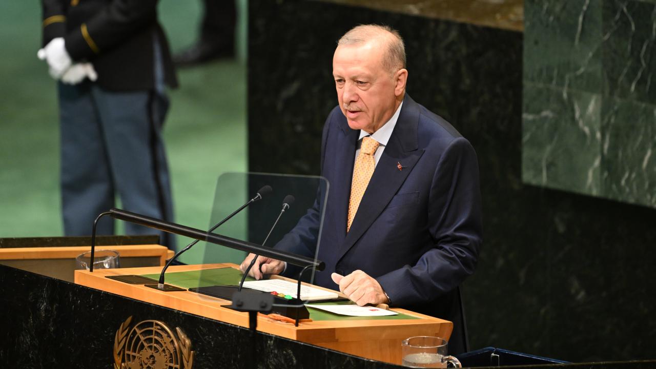 Cumhurbaşkanı Erdoğan konuşma yaparken konuşma kürsüsünde ve Türk bayrağı arka planda
