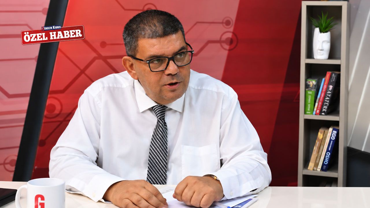 Berova konuşurken ciddi ifadeyle mikrofonun önünde duruyor