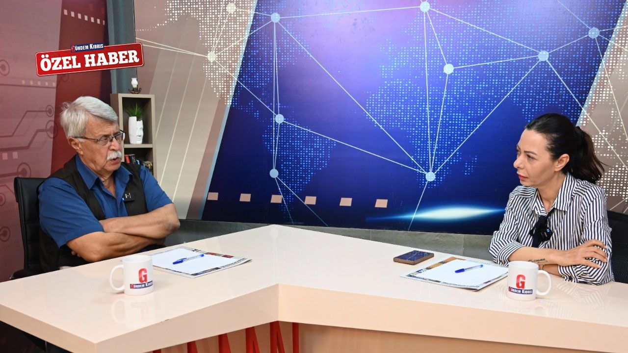 Soyer konuşma yaparken kürsü ve arka planda muhitle ilgili görseller veya afişler