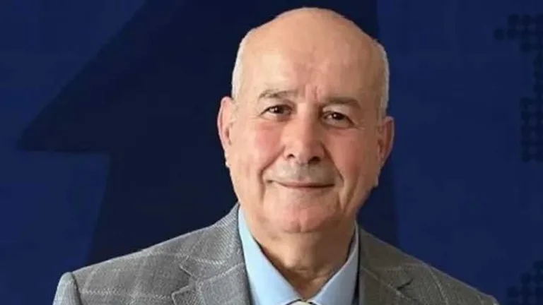 Aziz Gülbahar konuşurken mikrofon önünde ciddi ifadeyle oturuyor