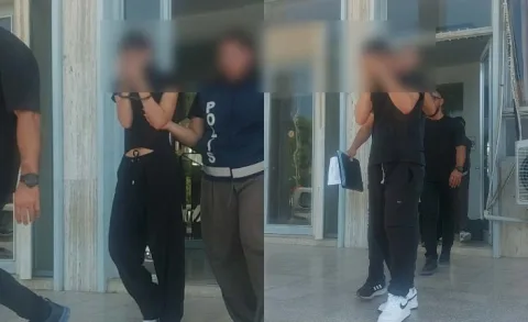 İki tutuklu kişi kelepçeli halde, çevrelerinde güvenlik görevlileri bulunuyor