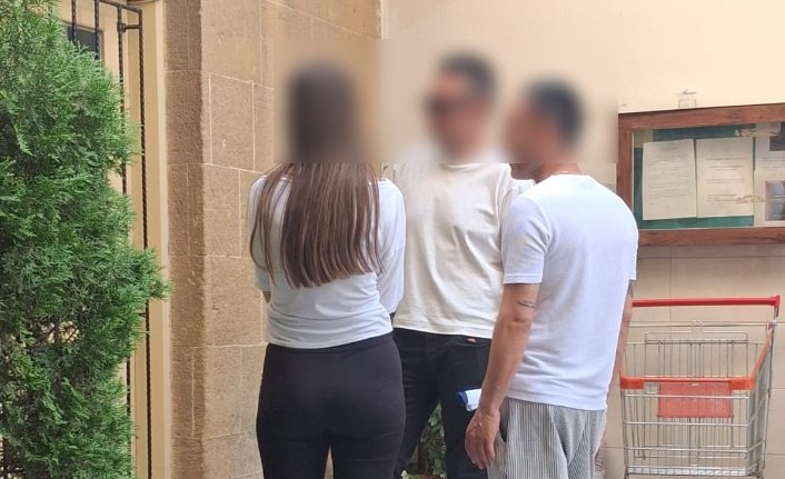 Karakol önünde elleri kelepçeli bir kişinin polis çevresinde bekleyişi